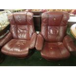 Pair of Ekornes Stressless swivel reclining armchairs with footstools in burgundy leather. As
