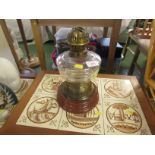 Glass bodied oil lamp on ceramic base.