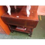 Oak drop leaf two tier occasional table with single drawer.