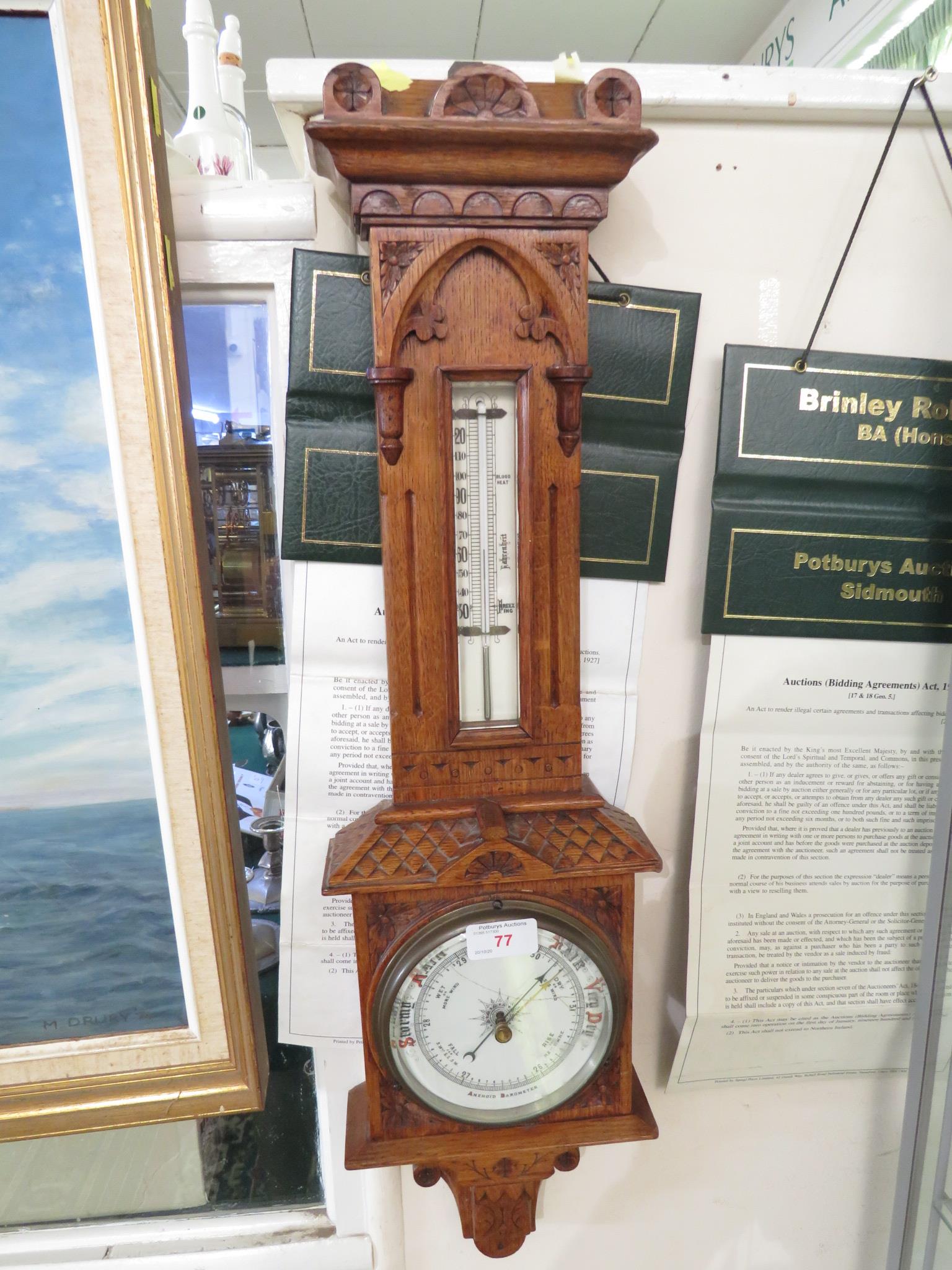 ANEROID BAROMETER AND THERMOMETER ON A CARVED OAK MOUNT