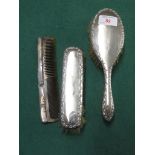 TWO SILVER BACKED DRESSING TABLE BRUSHES MATCHED WITH A SILVER BACKED COMB