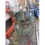 A GREEN METAL FLOWER BASKET HOLDER WITH THREE TIERS