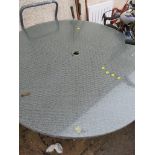 A PATIO TABLE WITH GLASS TOP AND PARASOL