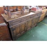 RUSTIC OAK SIDEBOARD WITH THREE DRAWERS TO TOP, CARVED FOLAIGE AND TWO CUPBOARDS TO BASE (WITH ONE