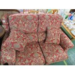 A PARKER KNOLL TWO-SEATER SOFA IN RED UPHOLSTERY, ON BRASS CASTERS