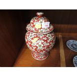 A FAR EASTERN PORCELAIN URN, RED GROUND WITH FLORAL DECORATION, HEIGHT 25.5CM