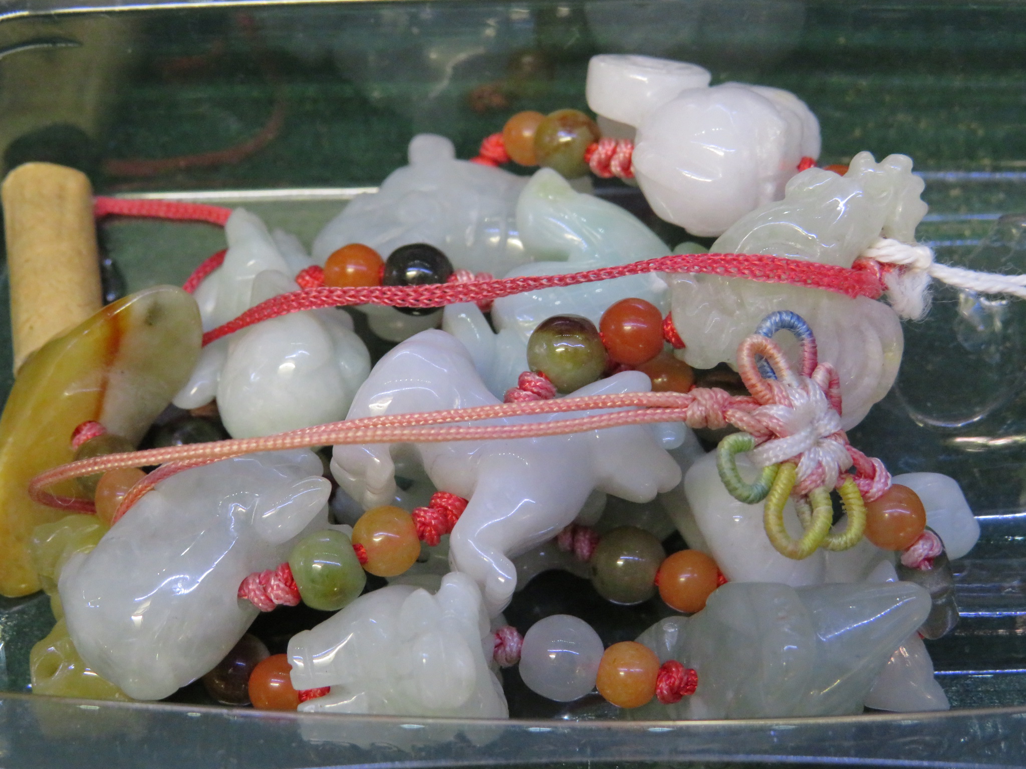 TWELVE THREADED CARVED HARDSTONE ANIMALS BETWEEN POLISHED BEADS