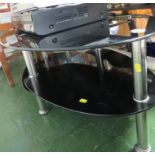 A THREE TIER OVAL BLACK GLASS TELEVISION STAND