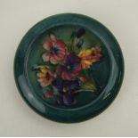 A Moorcroft round dish decorated in the Spring Flowers design: circa 1950's, 11.5cm in dia, tiny