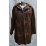 A Brown Musquash fur ladies Coat: Size 14, three quarter length.