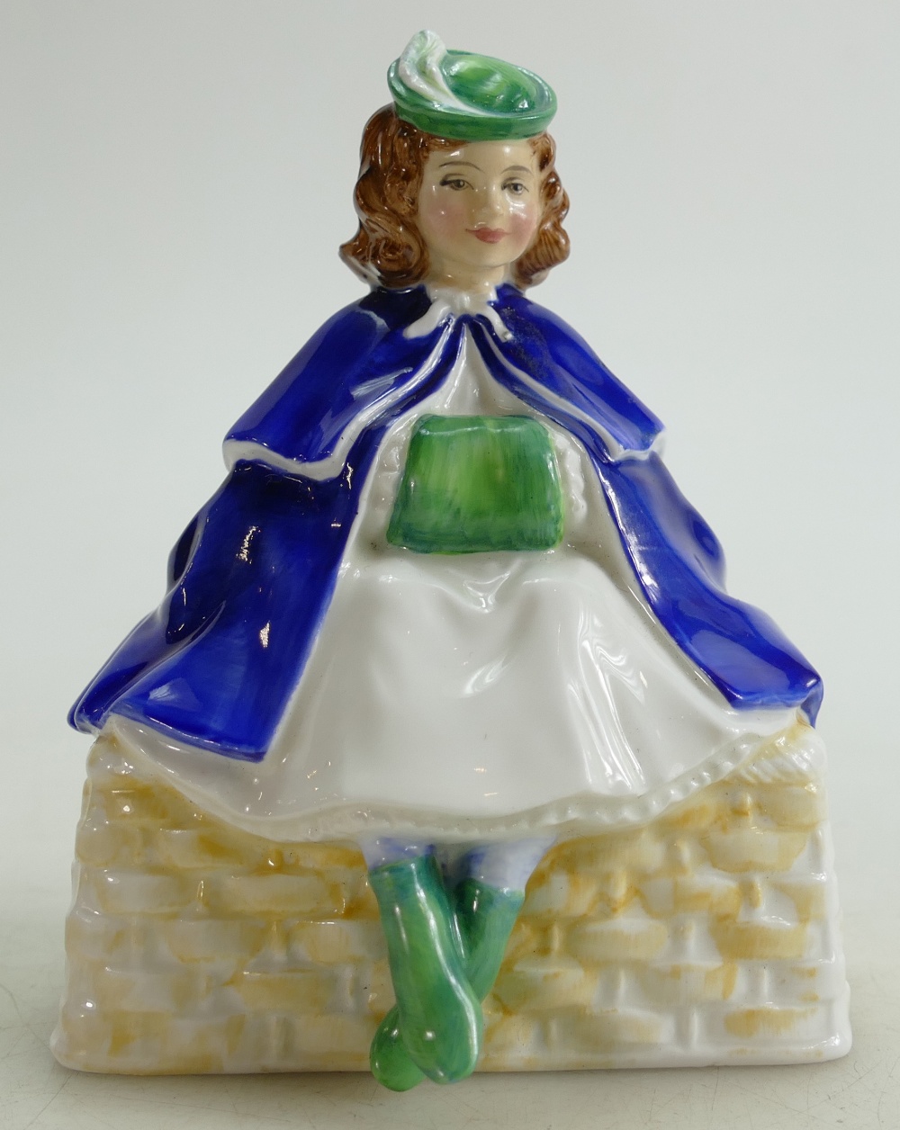Royal Doulton prototype figure of a seated Girl on a basket with hands in muff: Figure height 14cm.