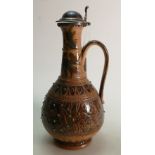 Doulton Lambeth Stoneware Jug: Decorated with scrolling foliage and silver lid, height 28.5cm.
