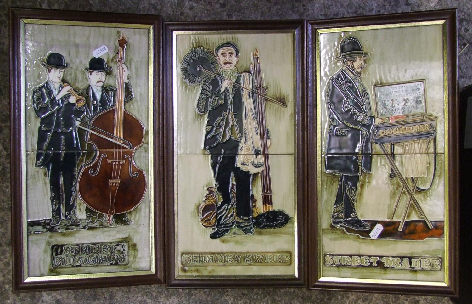 Three framed tiled plaques: with street musicians, chimney sweep and street trader.