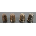 four hallmarked silver thimbles.