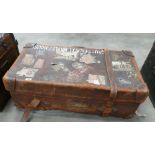 Large Heavy Distressed Leather Travelling trunk: brass lock with multiple travel stickers including