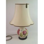 Moorcroft lamp decorated with the Magnolia design: on wood plinth and shade, overall height 59cm.