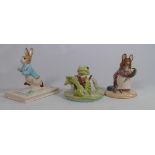 A collection of Beatrix Potter figurines: Peter on his book P4217, Hunca Munca and Jeremy Fisher