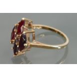 9ct gold dress ring set with four garnets; size N/O, 2.9 grams.