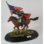 A ceramic figure of a cowboy riding a horse: on wooden plinth