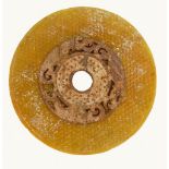 A Chinese Liuli bi disc plus one other: Disc of circular form in yellow/orange colour, diameter 21.