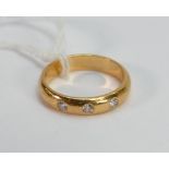 Yellow metal diamond wedding band: tested to be high carat with three gypsy set diamonds, size M, 5.