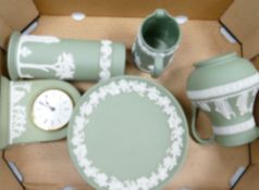 A collection of Wedgwood sage green items to include: jugs, small tazza, mantle clock,