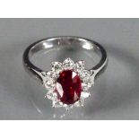 18ct White gold ladies ring set with an oval Garnet surrounded by Diamonds: Size M, 4.3g.