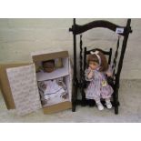 A boxed Ashton Drake Galleries limited edition boxed doll: together with a doll seated on a wooden