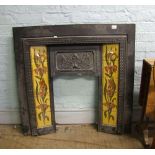 A cast iron Art Noveau style fire surround: with tiled inserts. Makers name F Fireplace factors UK