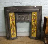 A cast iron Art Noveau style fire surround: with tiled inserts. Makers name F Fireplace factors UK