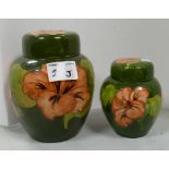 Two Moorcroft hibiscus ginger jars: on green ground.