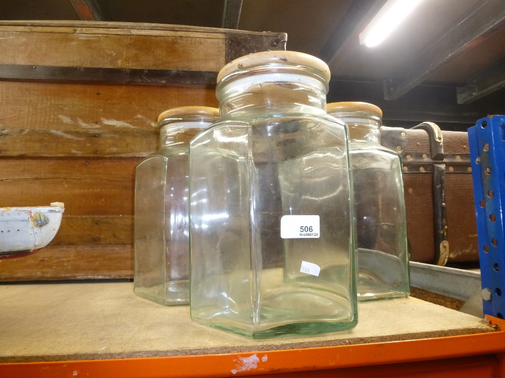 Three large hexagonal wooden topped storage jars.