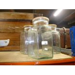 Three large hexagonal wooden topped storage jars.