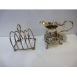 Small silver cream jug with embossed flower & leaf decoration 'S' scroll handle on 3 short