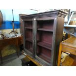 A stained pine bookcase with glazed doors