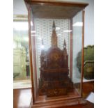 A wooden model of continental Church in a Victorian mahogany display case, height 112cms.