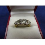 Three stone diamond ring with 6 small diamonds on a yellow coloured metal shank, unmarked size M/N