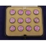 Set of 12 early 20th century small sterling silver & pink enamel buttons in a brown tooled leather