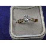 Solitaire diamond ring on a 9ct yellow gold shank set with 4 diamonds either side, diamond 0.75ct,