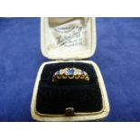 18ct yellow gold ring set with 3 pale blue sapphires and 2 small diamonds, shank stamped 18 and J.