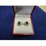 Pair of sapphire and diamond cluster style ear studs, with 14k yellow gold butterfly backs, gross