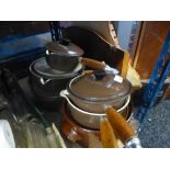 A small quantity of brown Le Creuset pots with lids, etc