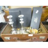 A vintage leather case filled with silver plate pens to include candlesticks, cutlery, cream dish,