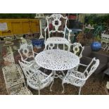 A vintage ornate garden set to include 5 carver chairs and a round table