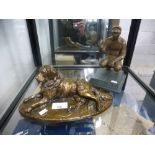 A bronzed retriever dog and a bronze sports figure on a plaque