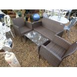A rattan style brown garden set comprising of sofa, 2 armchairs and glass topped table