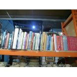 A half shelf of hardback books of various themes, etc