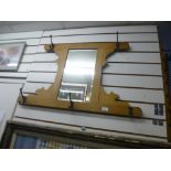 A wooden framed mirror with coat hoooks