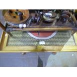 A small teak table having a glazed top showing a woven design