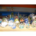 A quantity of a glass paper weights with flowers and various decoration, some marked